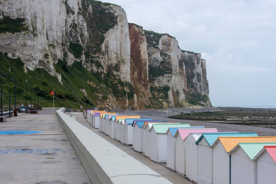 Vibrant beach huts line the promenade with stunning cliffs in Le Tréport, Normandy, France